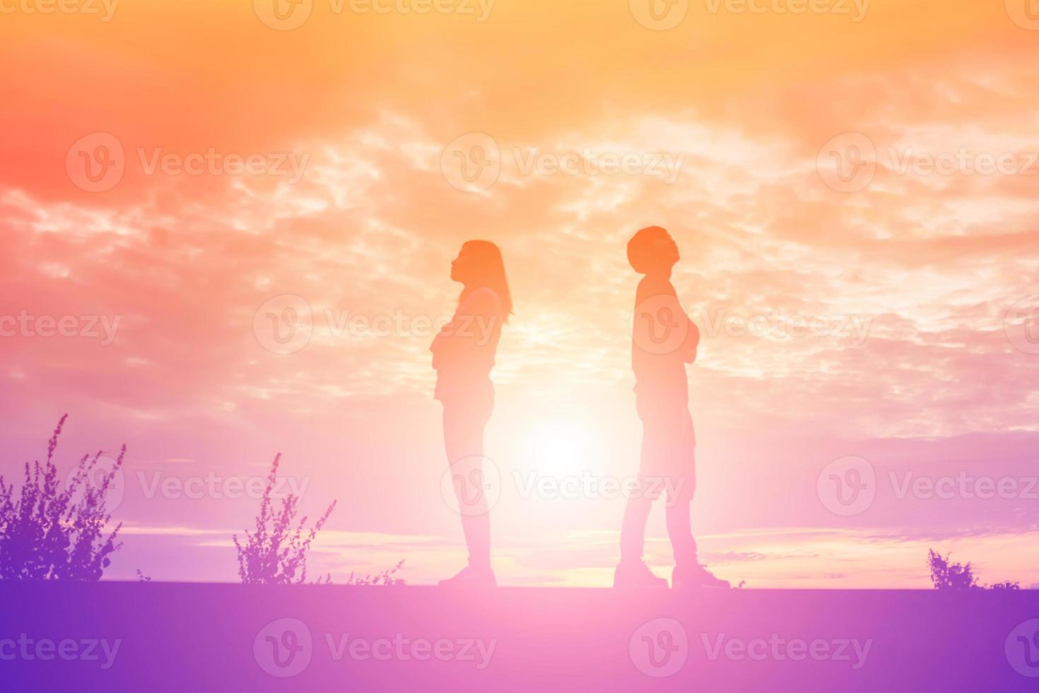 a silhouette of a man and woman holding hands with each other, walking together. photo