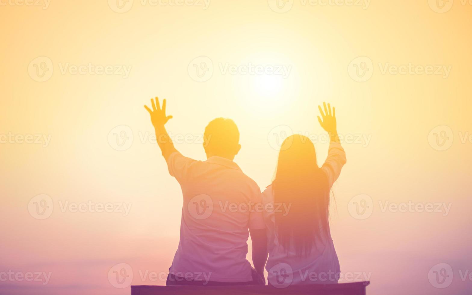 a silhouette of a man and woman holding hands with each other, walking together. photo