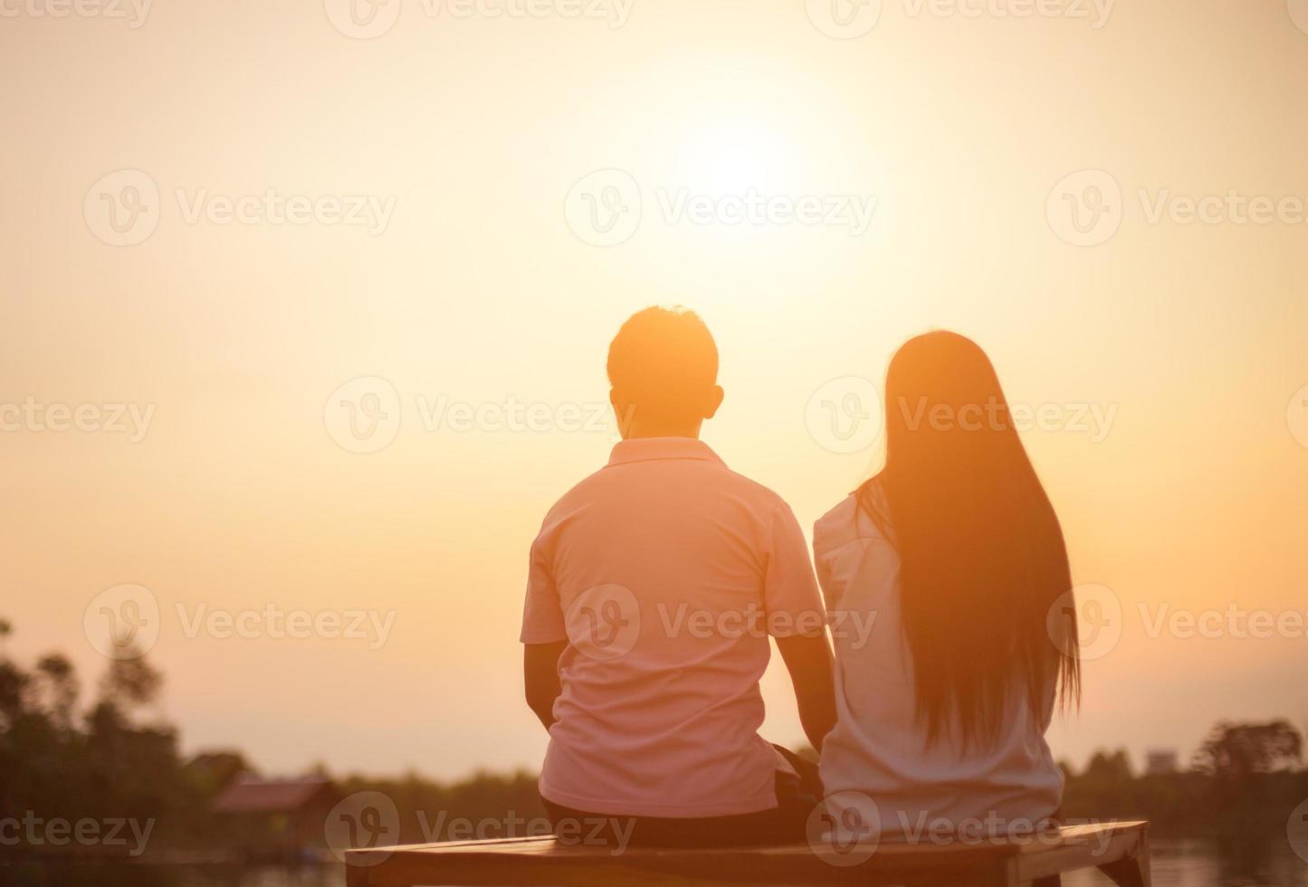 a silhouette of a man and woman holding hands with each other, walking together. photo