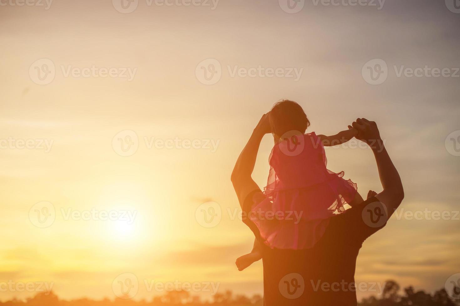 Father took the baby learn to walk at sunset. photo