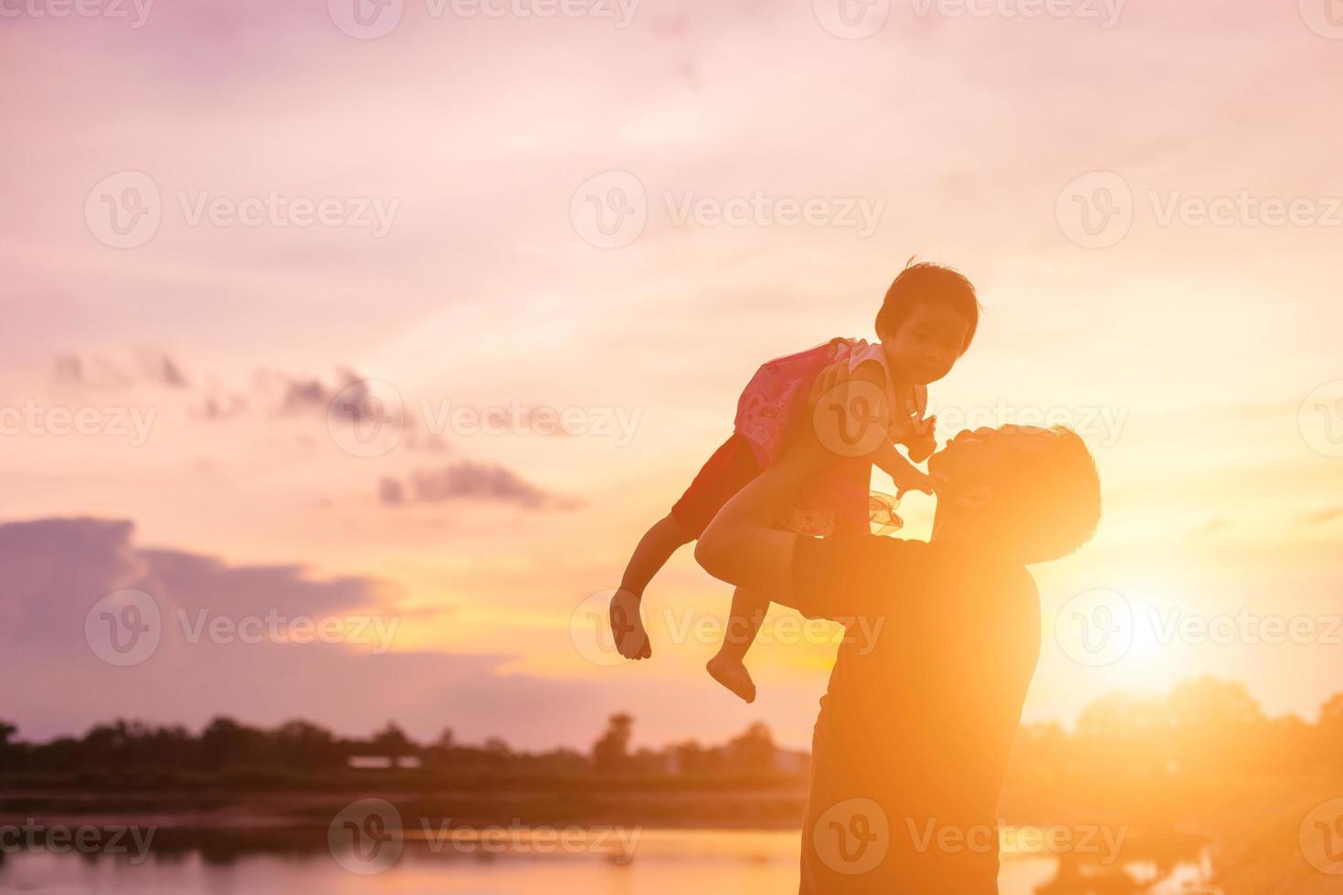 Father took the baby learn to walk at sunset. photo