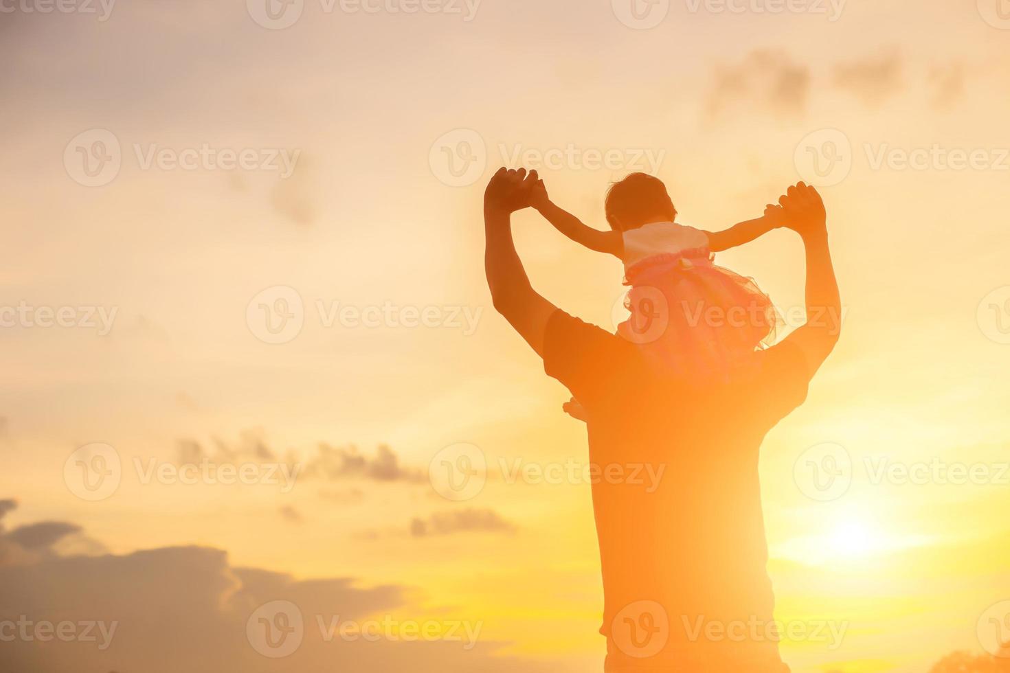 Father took the baby learn to walk at sunset. photo