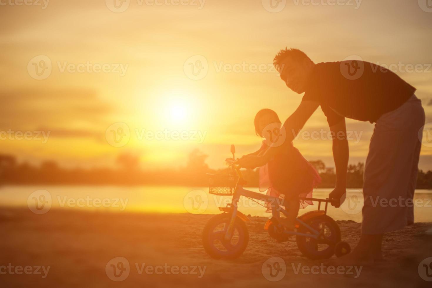 Father took the baby learn to walk at sunset. photo