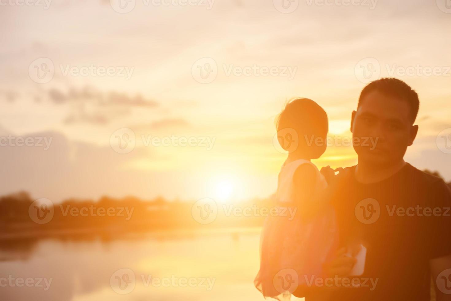 Father took the baby learn to walk at sunset. photo