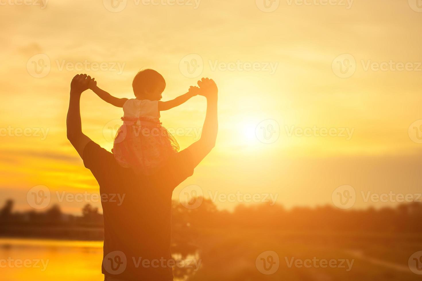 Father took the baby learn to walk at sunset. photo