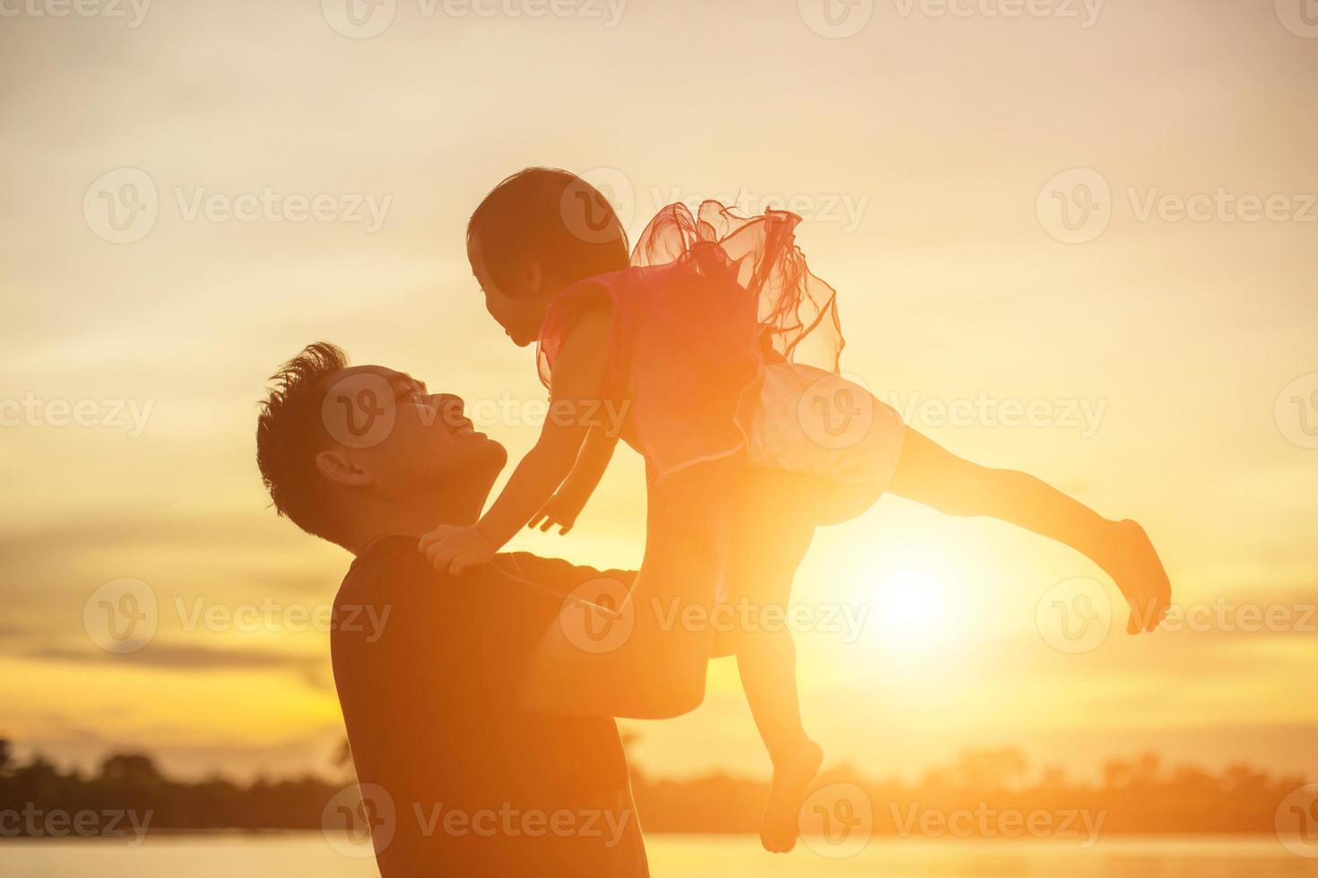 Father took the baby learn to walk at sunset. photo