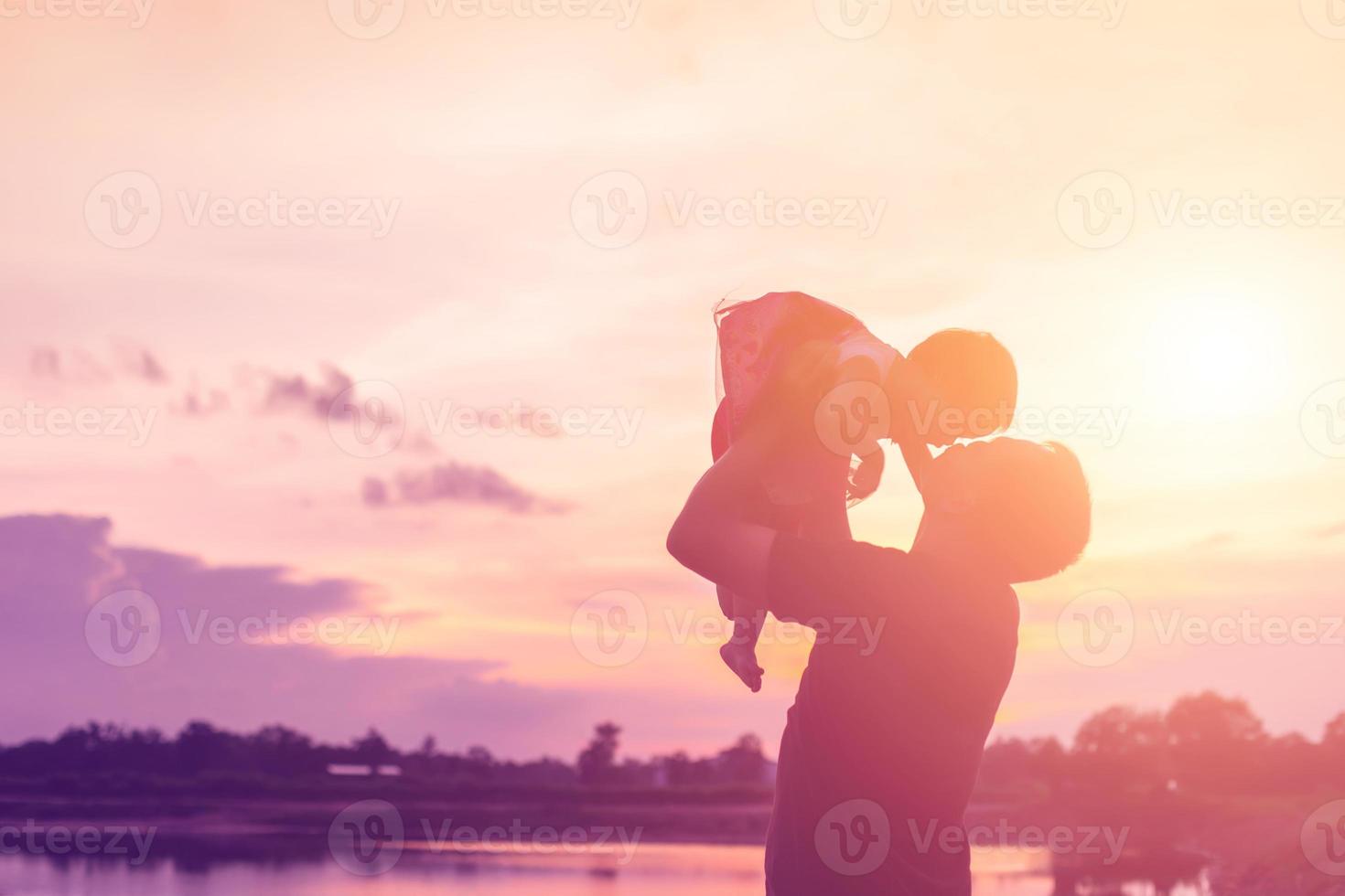 Father took the baby learn to walk at sunset. photo