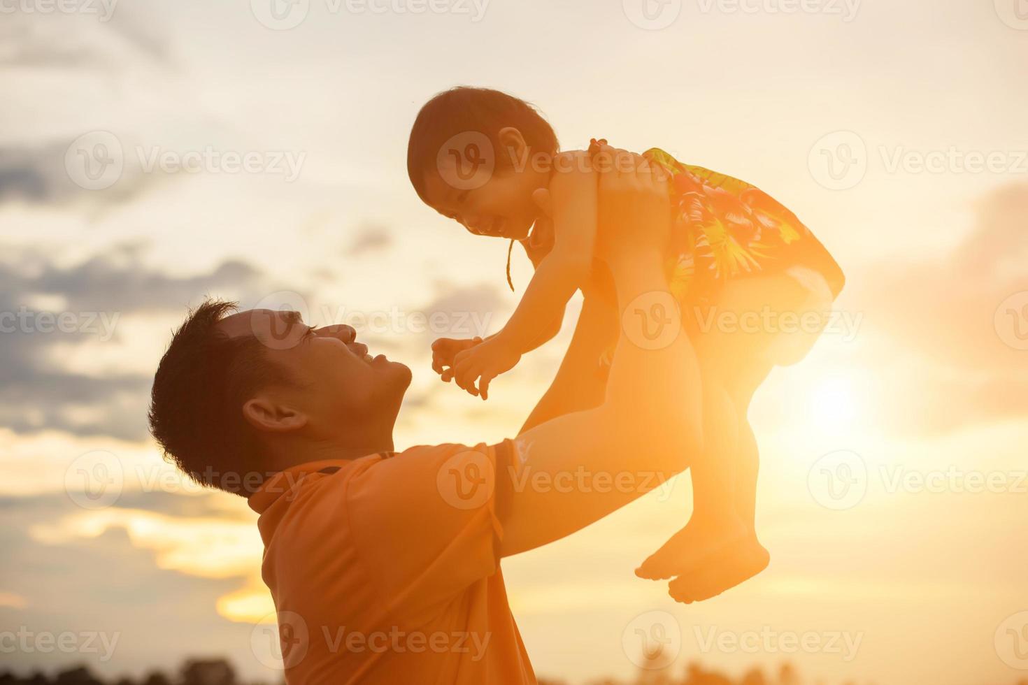 Father took the baby learn to walk at sunset. photo
