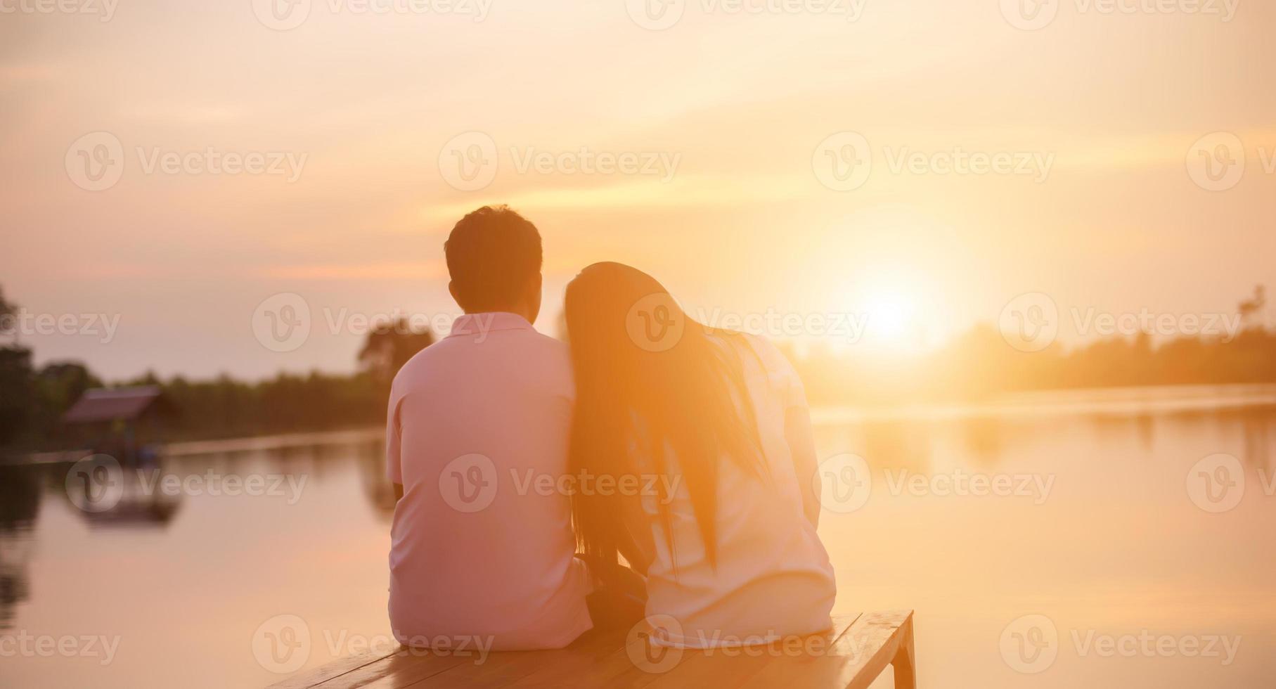 a silhouette of a man and woman holding hands with each other, walking together. photo