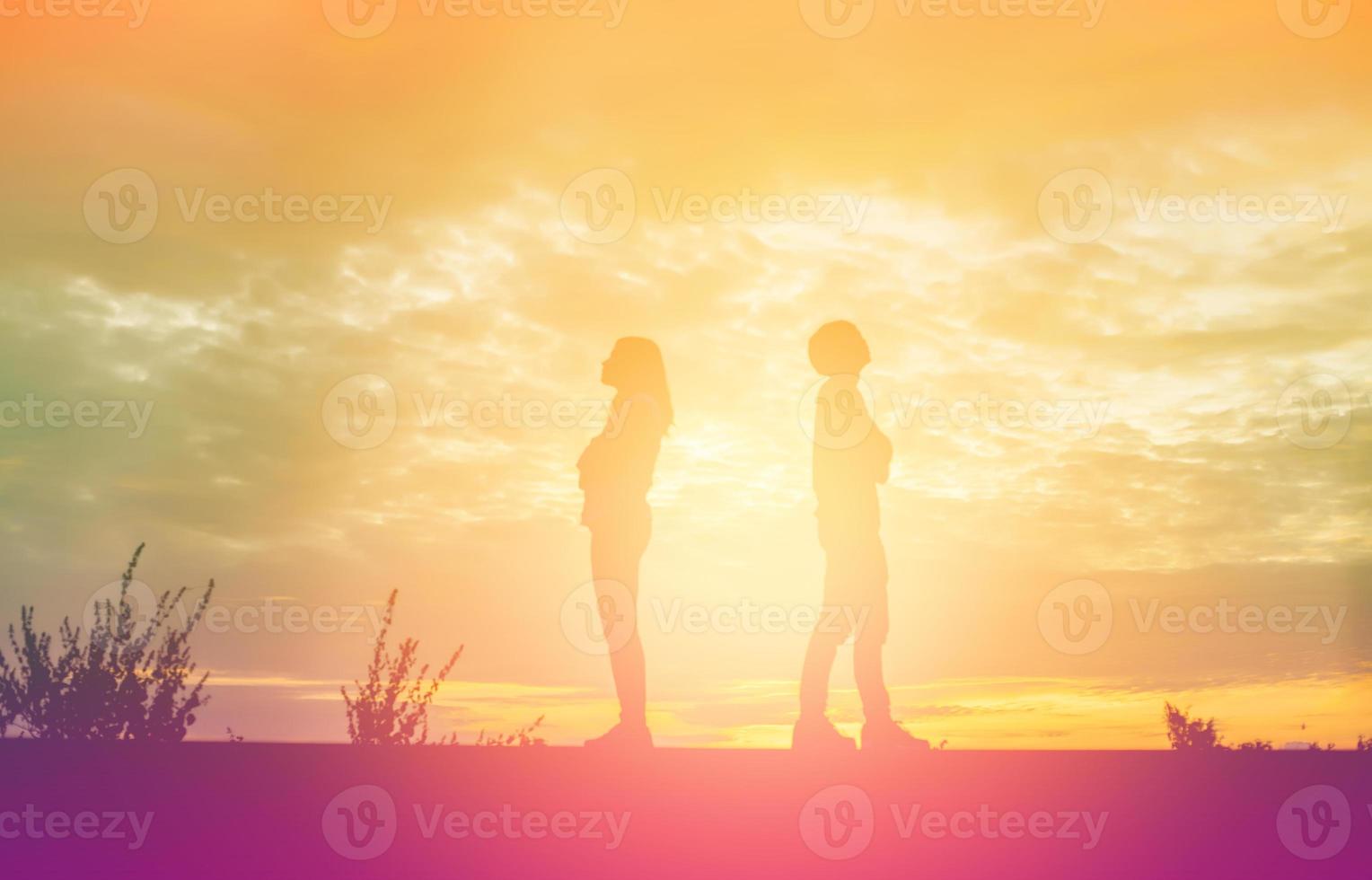 a silhouette of a man and woman holding hands with each other, walking together. photo