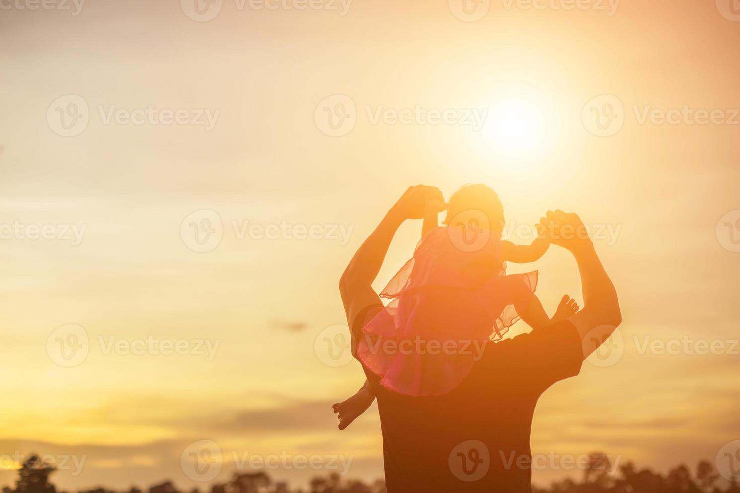 Father took the baby learn to walk at sunset. photo