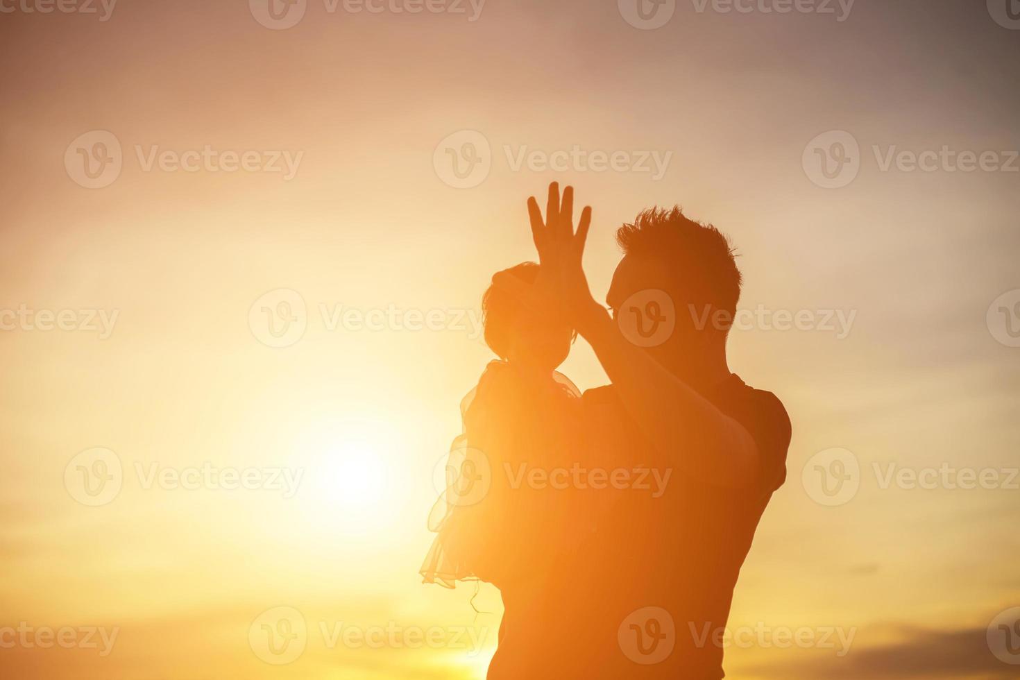 Father took the baby learn to walk at sunset. photo