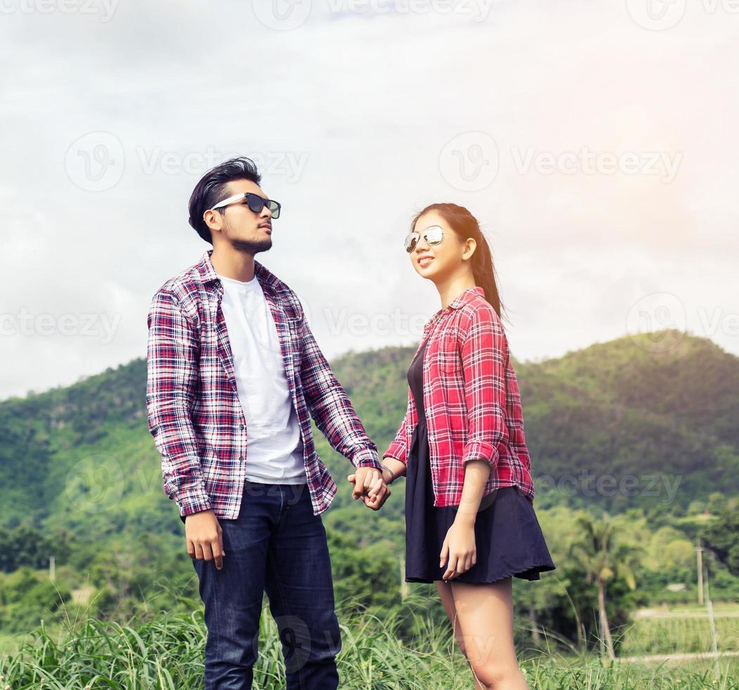 Young hipster couple holding hands walking on the meadow relaxing and natural atmosphere is very natural. photo