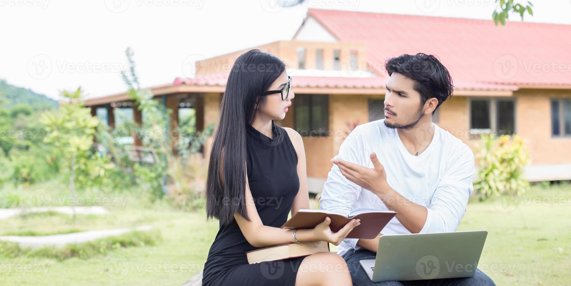 Young hipster couple enjoying a good read together while relaxing outdoors. photo