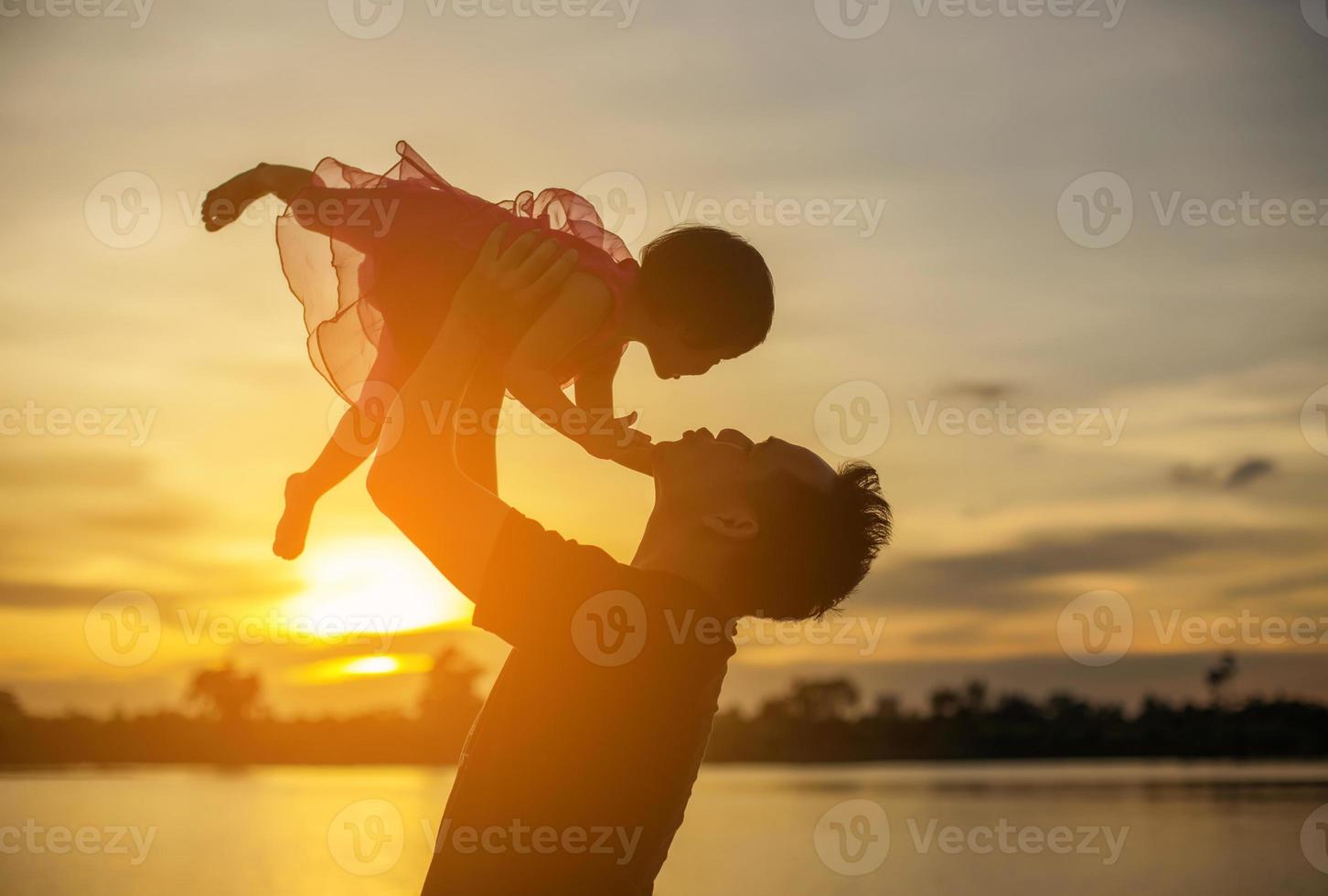 Father took the baby learn to walk at sunset. photo