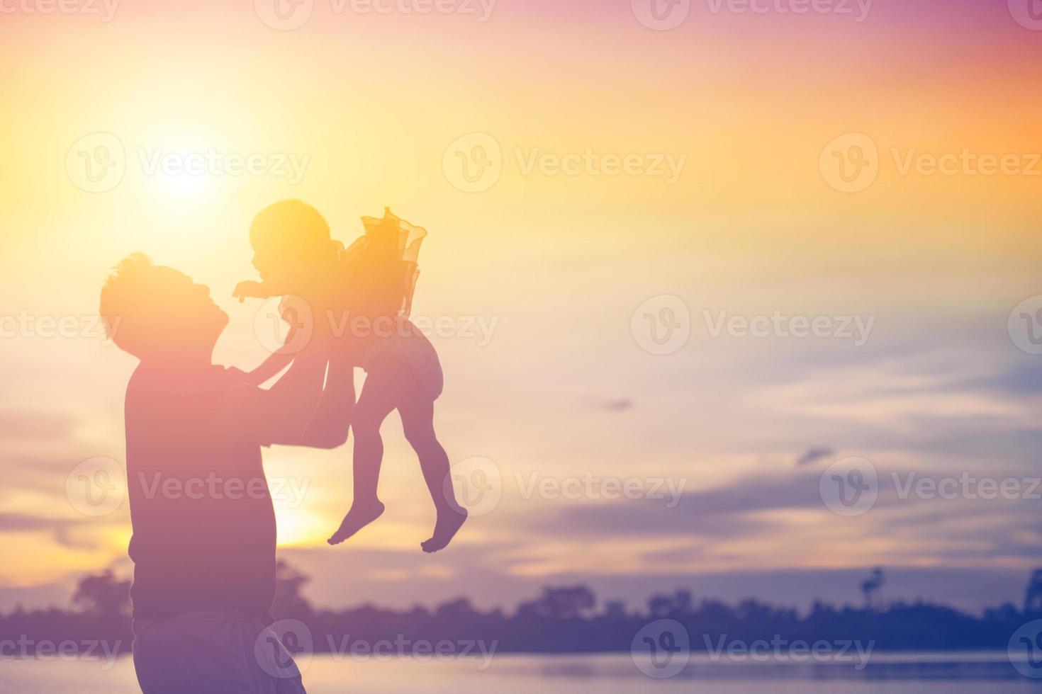 Father took the baby learn to walk at sunset. photo