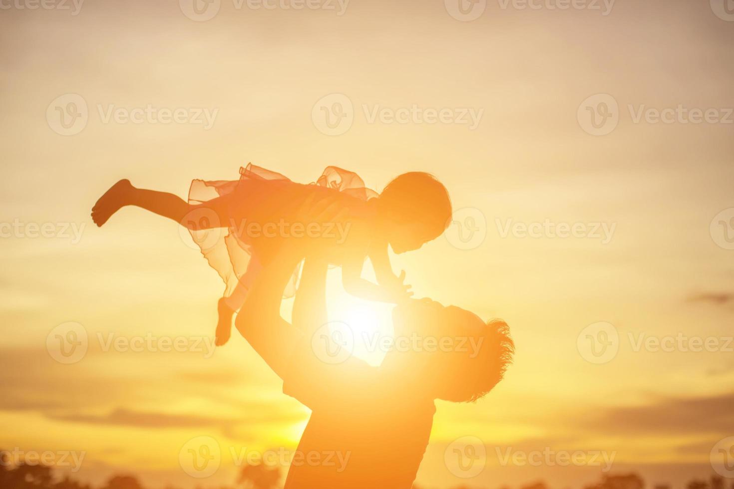 Father took the baby learn to walk at sunset. photo