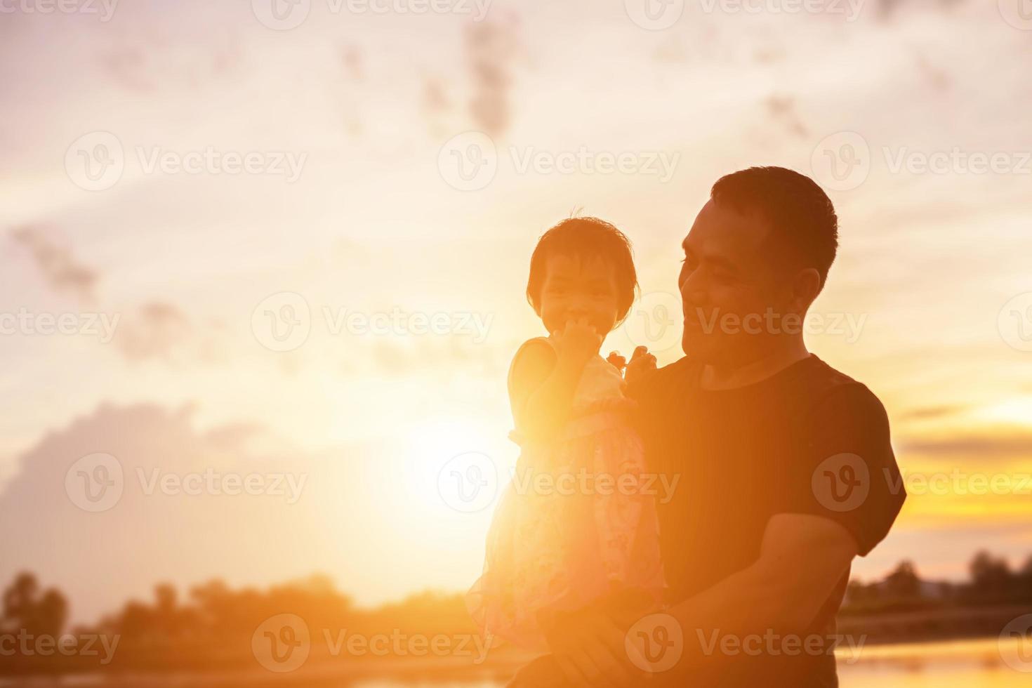 Father took the baby learn to walk at sunset. photo