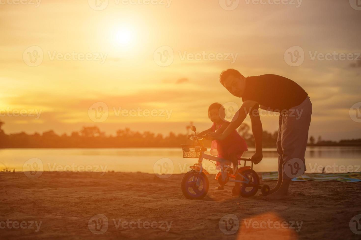 Father took the baby learn to walk at sunset. photo