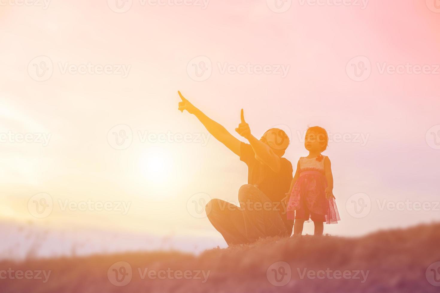 Father took the baby learn to walk at sunset. photo
