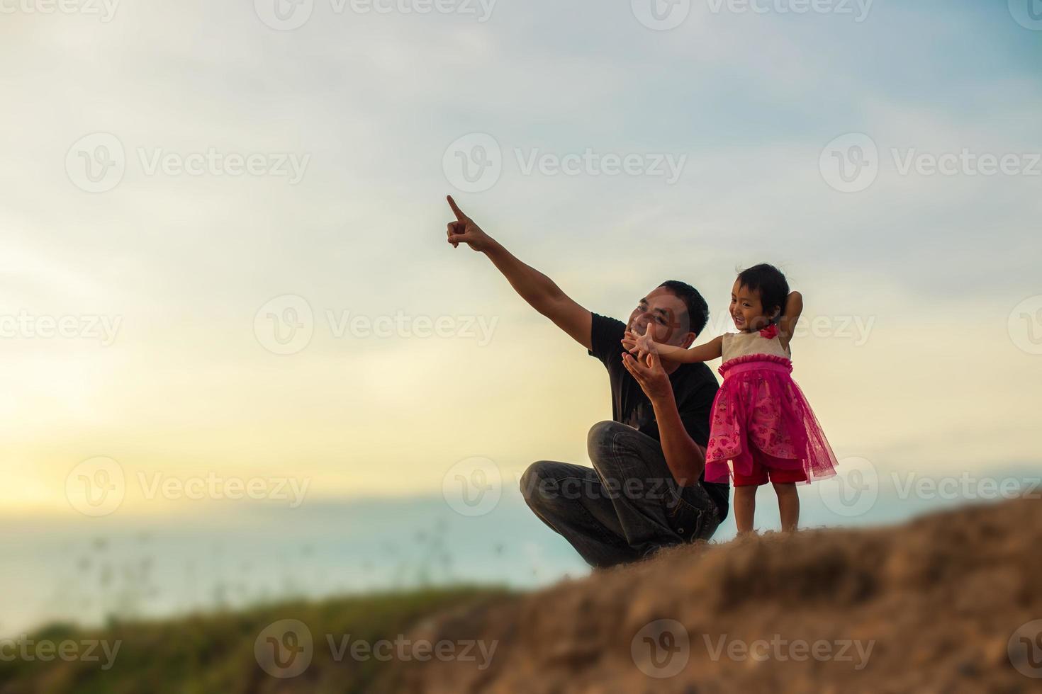 Father took the baby learn to walk at sunset. photo