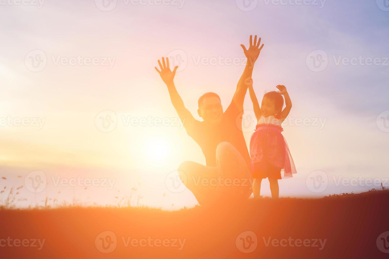 Father took the baby learn to walk at sunset. photo