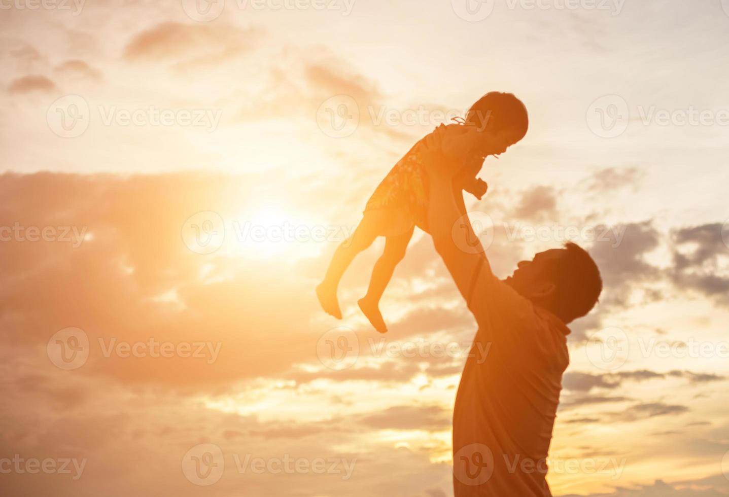 Father took the baby learn to walk at sunset. photo