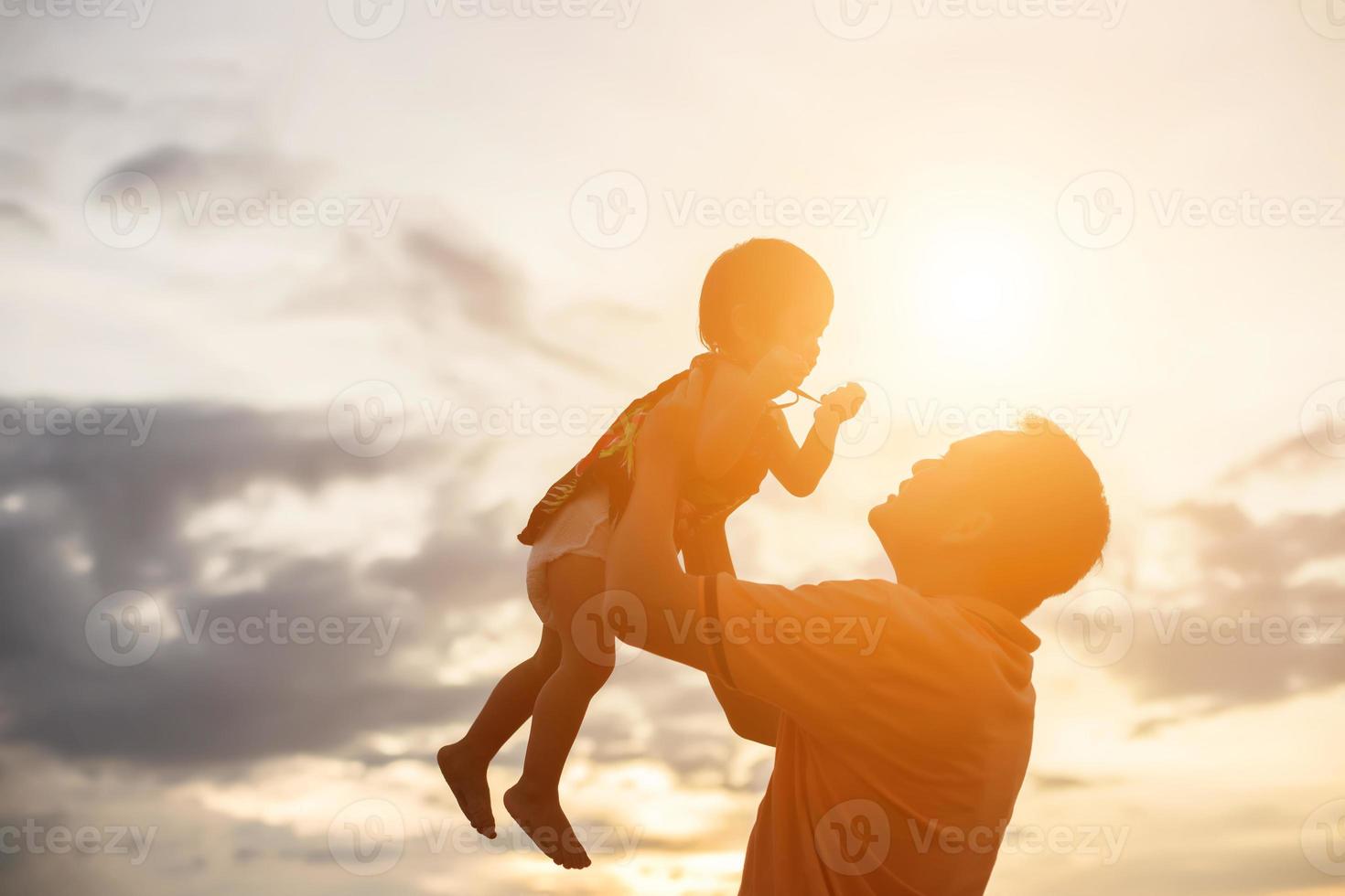 Father took the baby learn to walk at sunset. photo