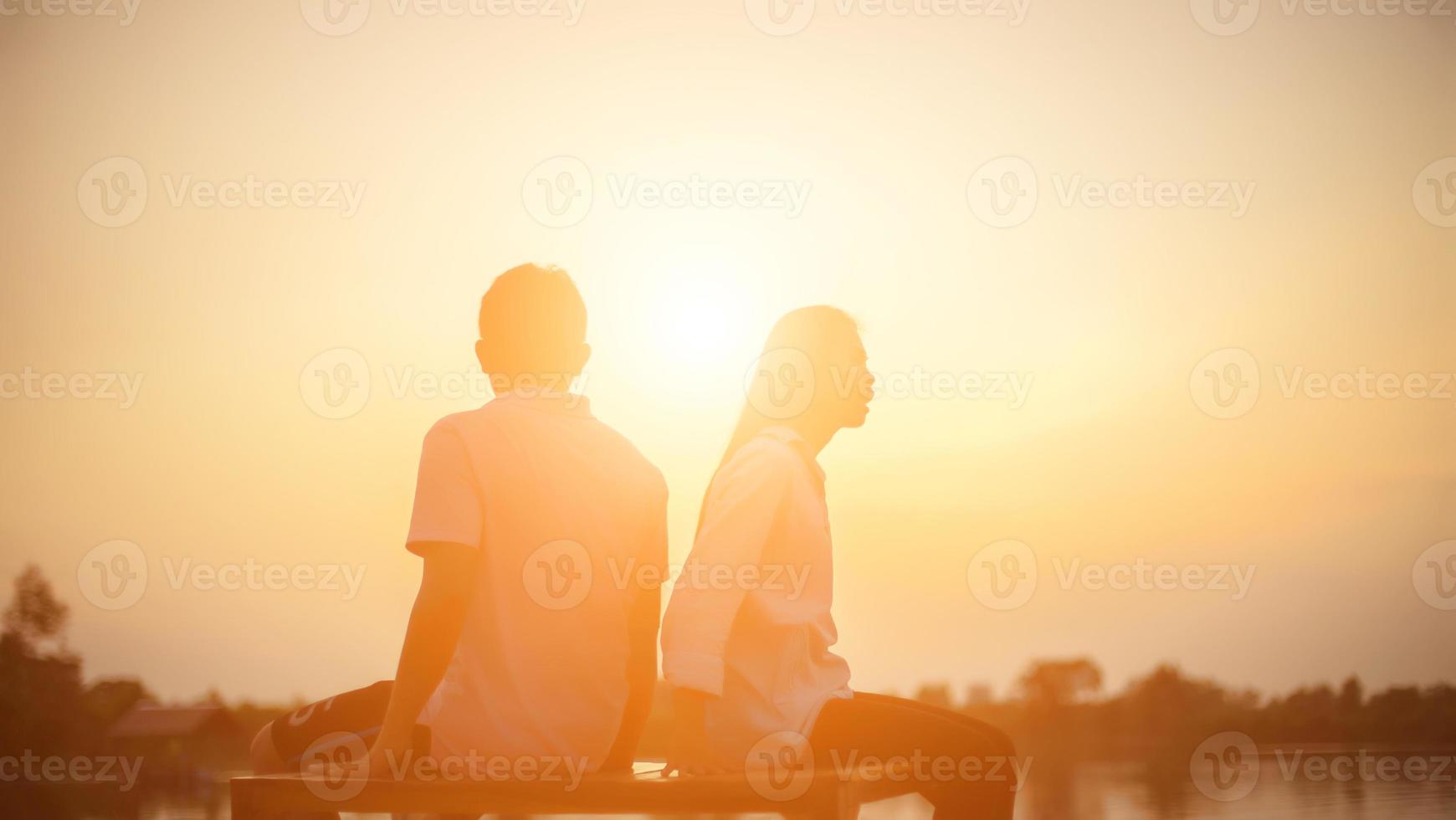 a silhouette of a man and woman holding hands with each other, walking together. photo
