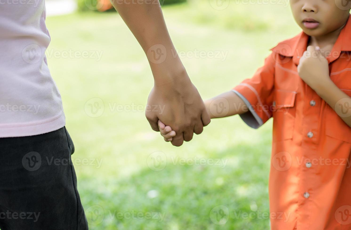 a the parent holds the hand of a small child photo