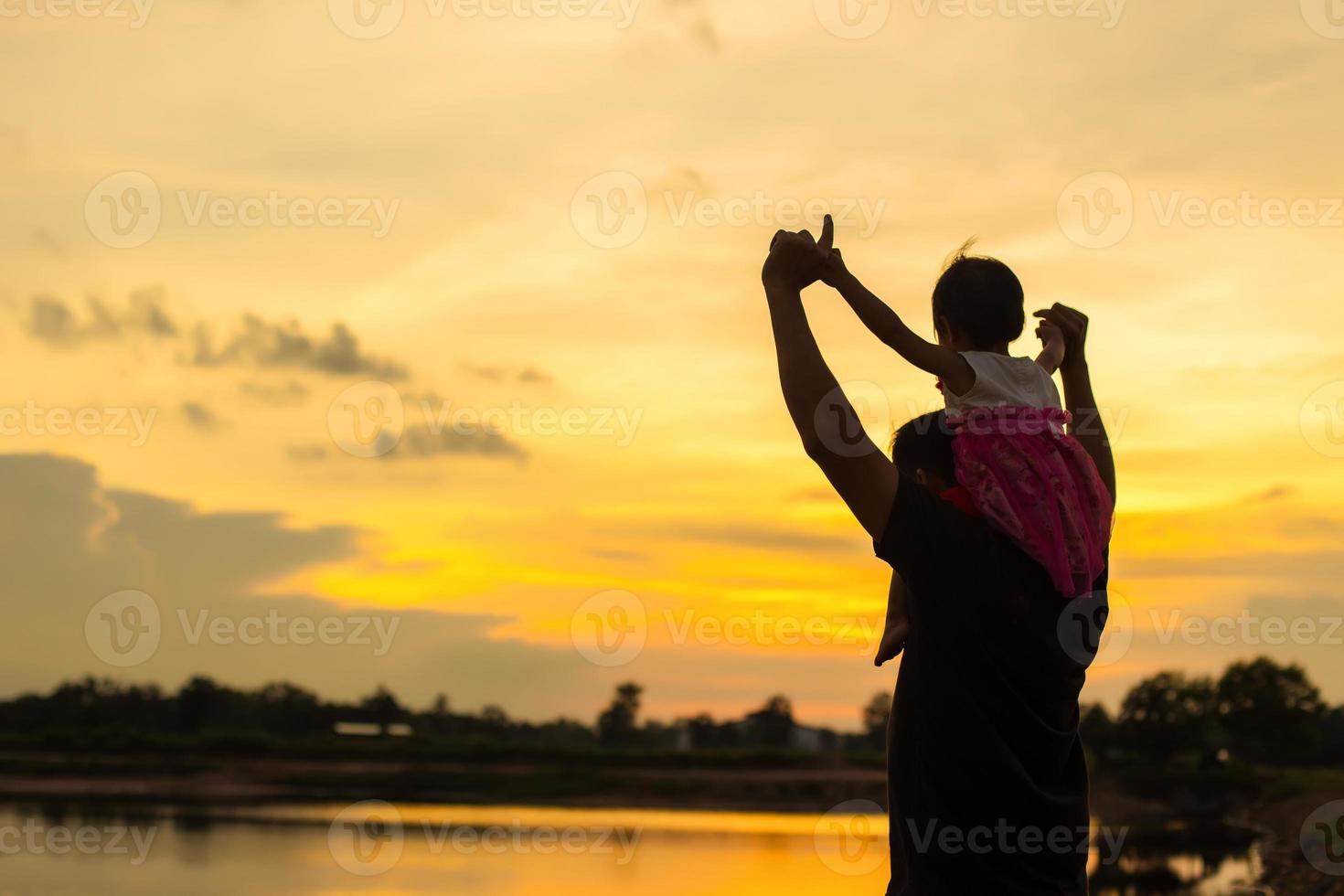 Father took the baby learn to walk at sunset. photo
