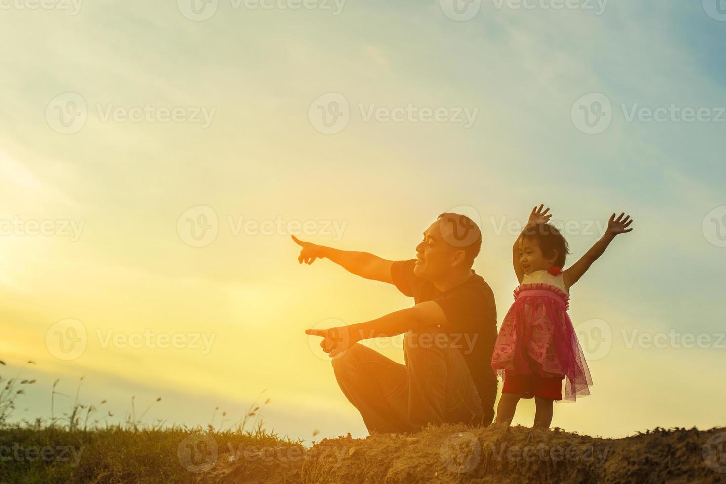 Father took the baby learn to walk at sunset. photo