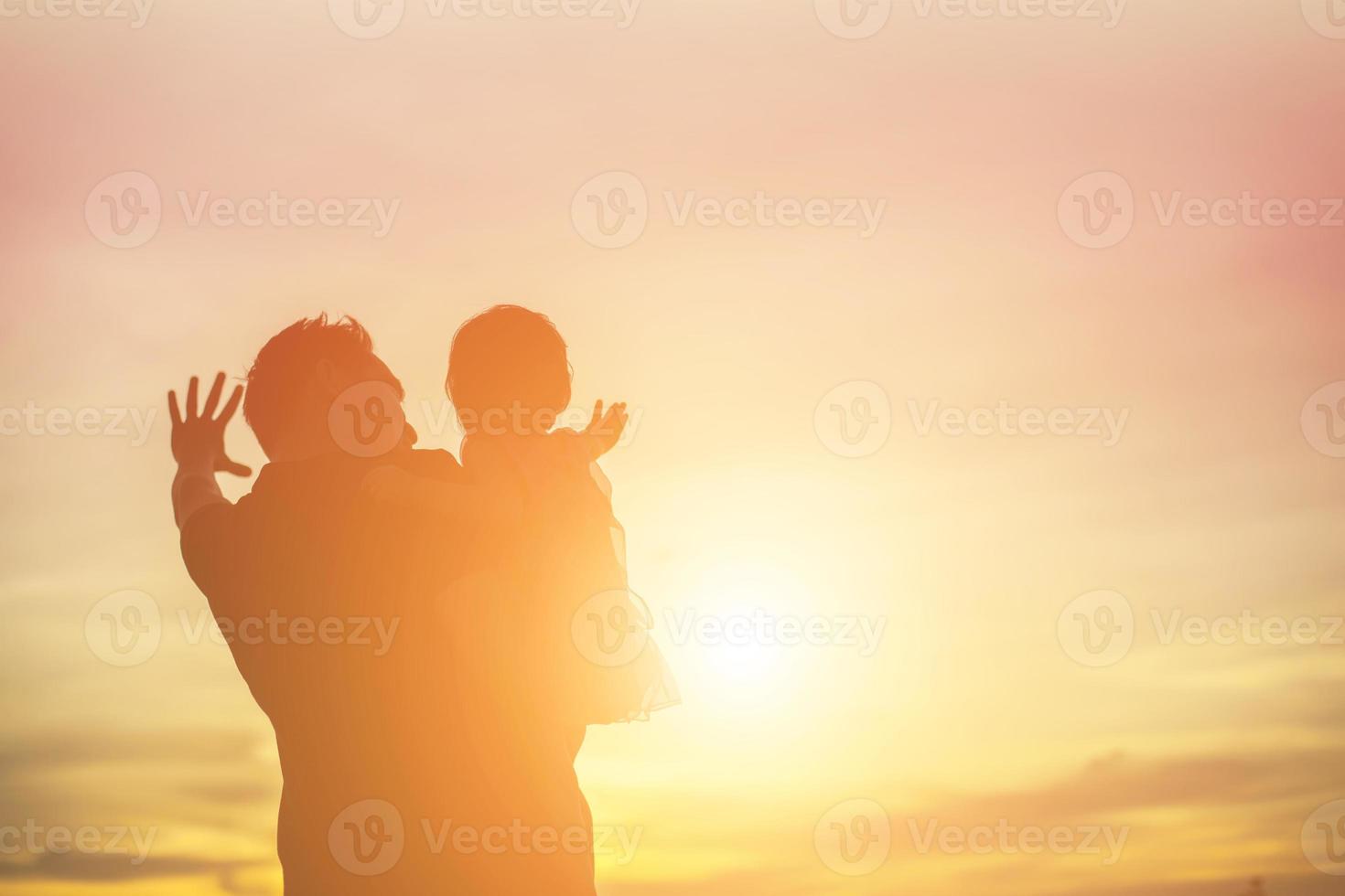 Father took the baby learn to walk at sunset. photo