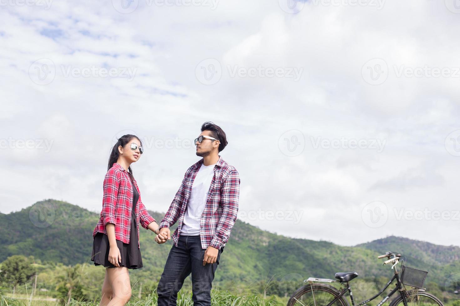 Young hipster couple holding hands walking on the meadow relaxing and natural atmosphere is very natural. photo
