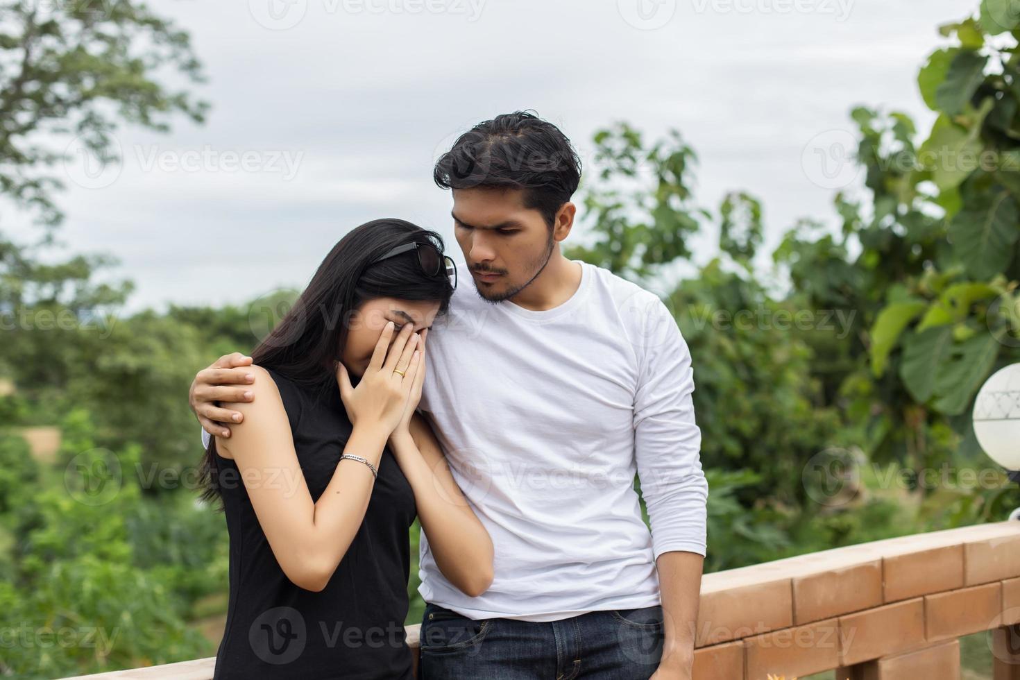 un joven y apuesto novio abrazando a su novia, ella estaba triste y molesta. foto