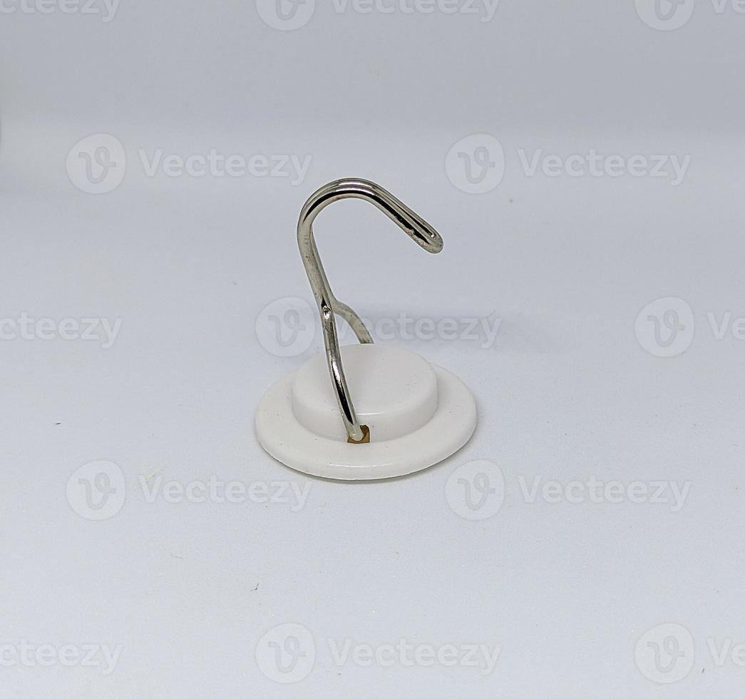 a white hanger or Hook made of plastic and iron with insulation to stick to the wall behind it isolated on a white background photo