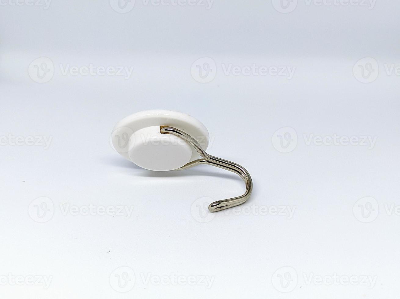 a white hanger or Hook made of plastic and iron with insulation to stick to the wall behind it isolated on a white background photo