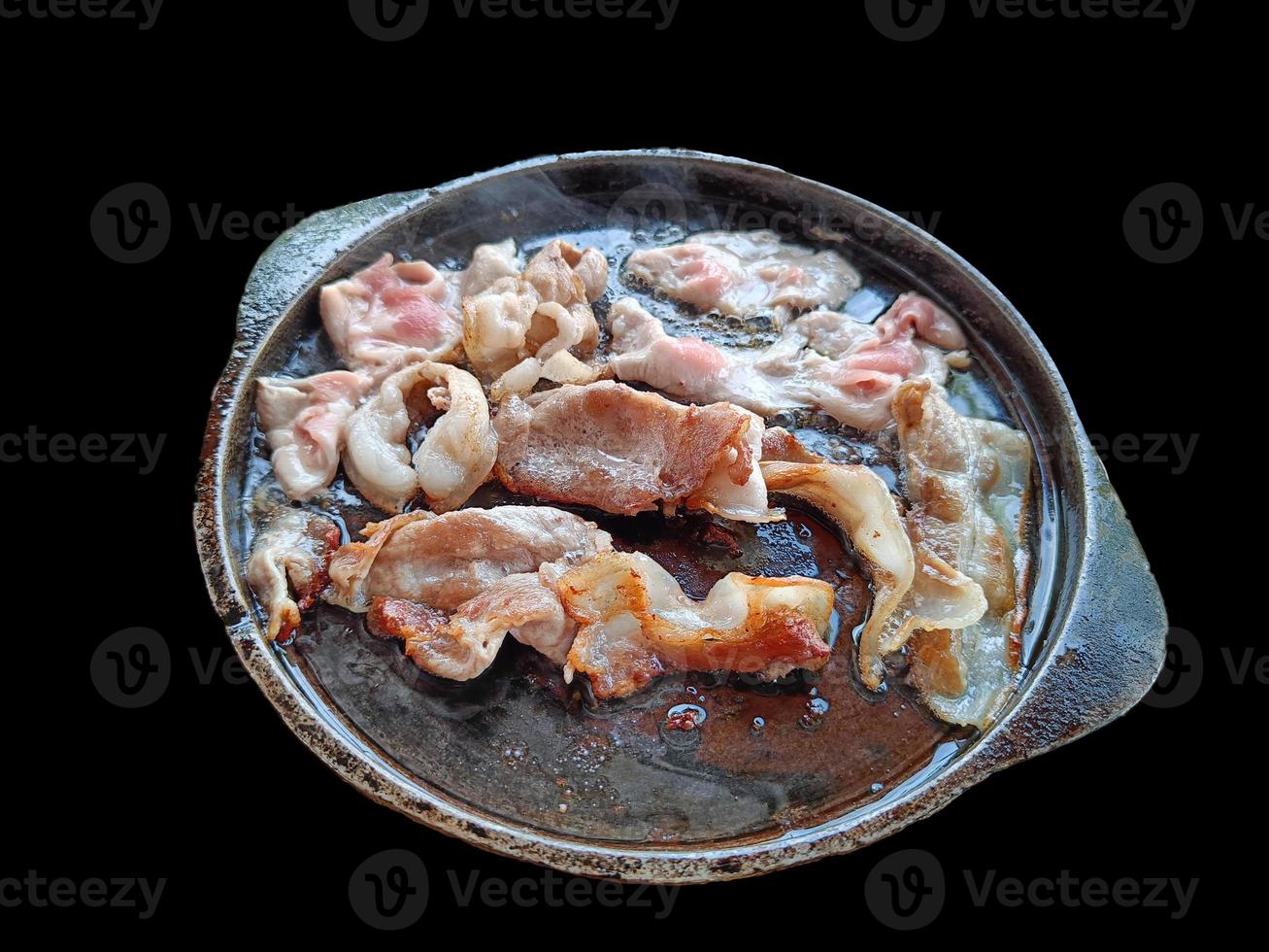 Grilled bacon on a hot pan isolated on black background with clipping path photo