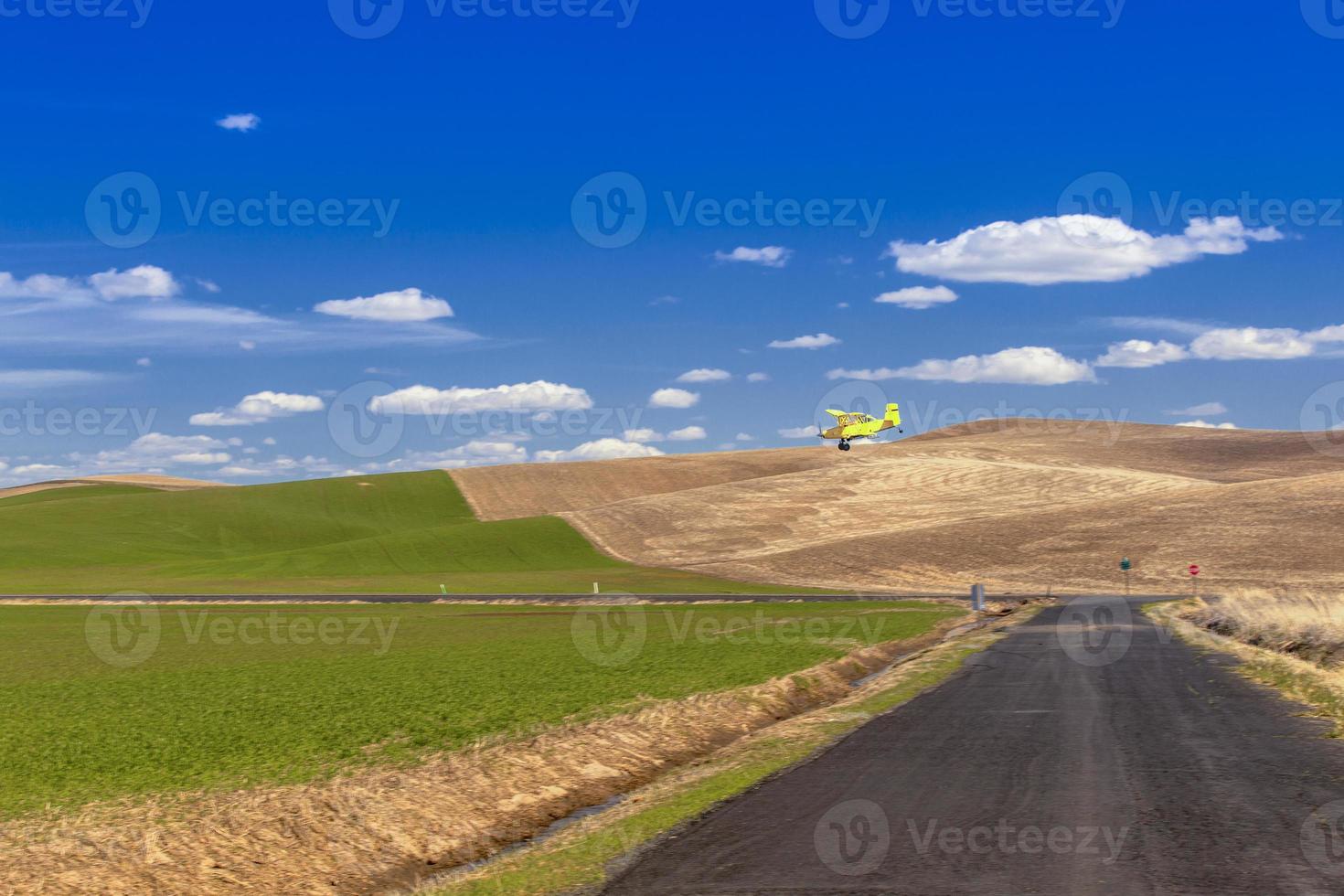 fumigador vuela sobre las colinas de palouse rociando fertilizante, washington, estados unidos foto