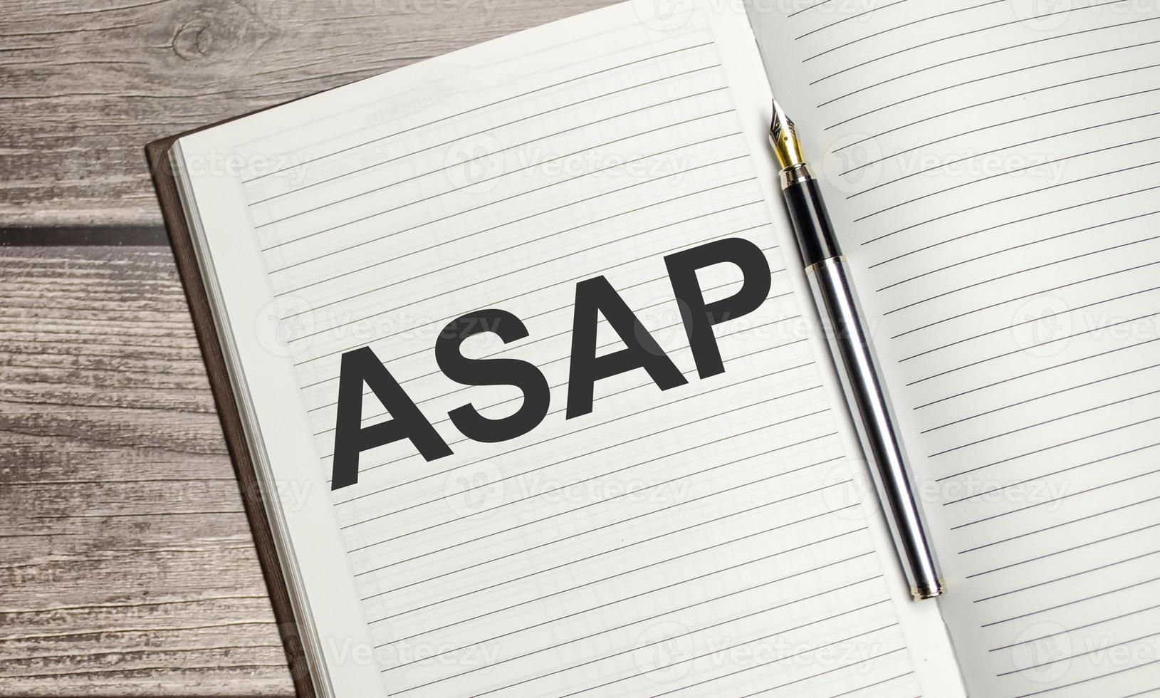 ASAP text on notepad with pen, business concept photo