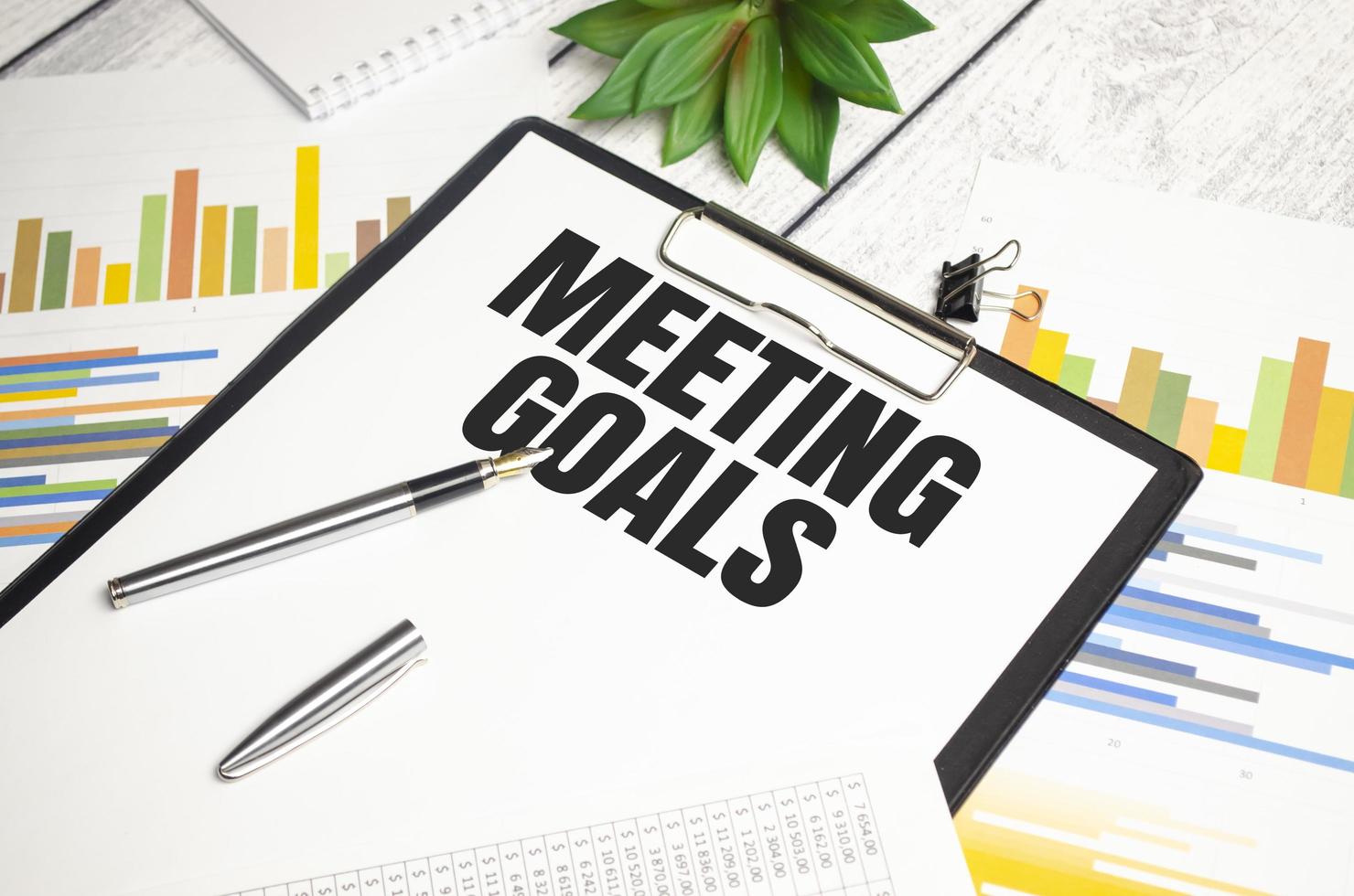Paper with text MEETING GOALS on the table on the chart photo