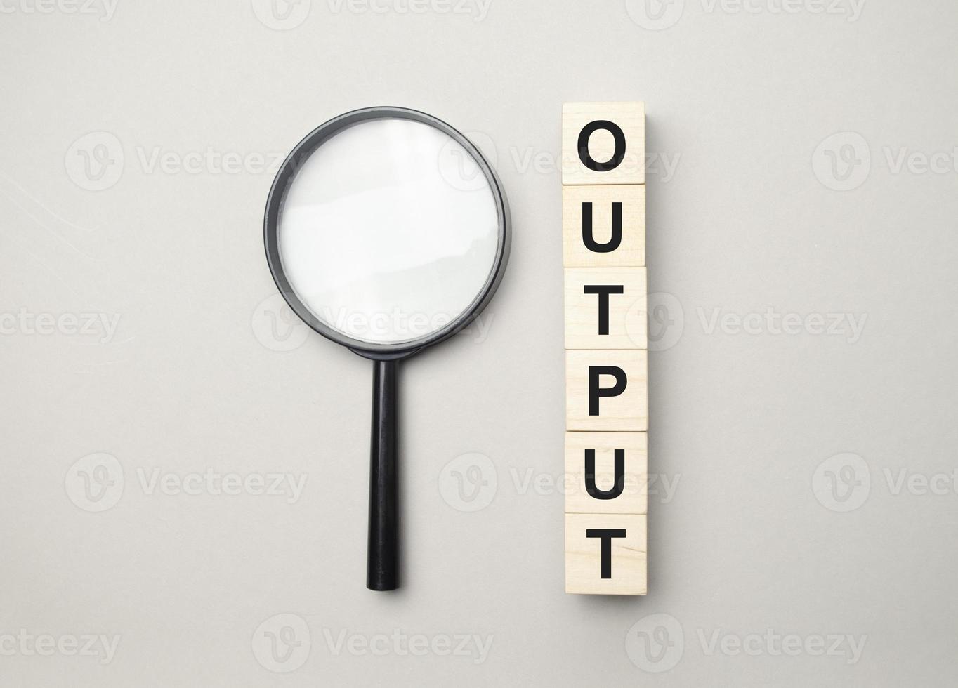 the wooden cubes with the word output and magnifier photo