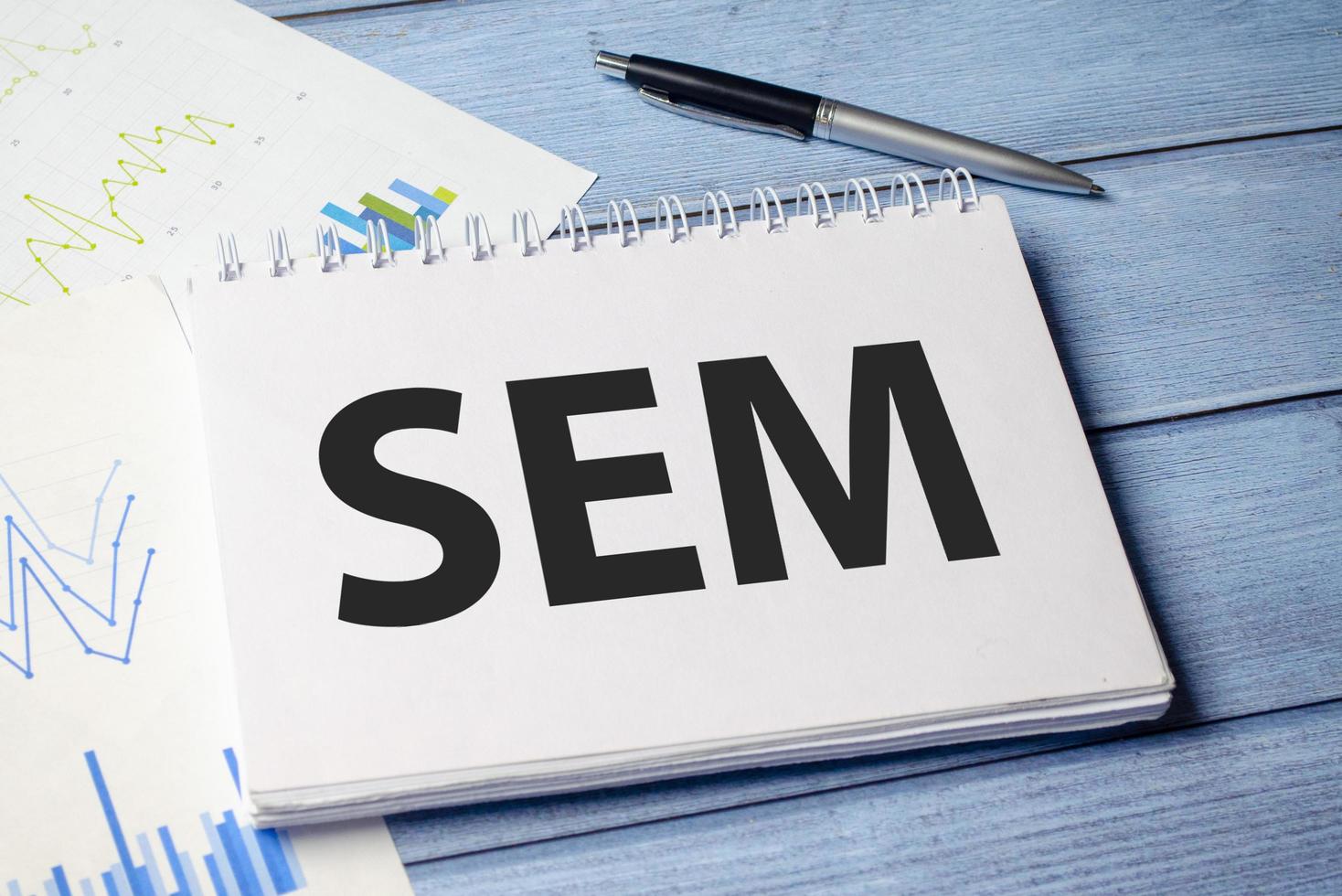 SEM Search Engine Marketing written in notebook on white table photo