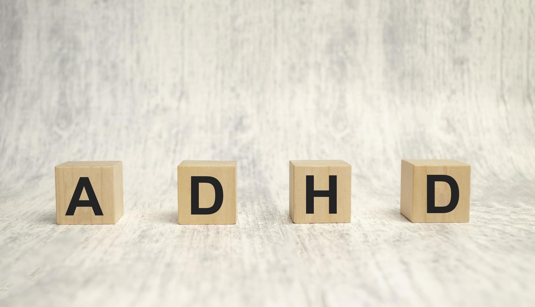 Concept of ADHD Attention Deficit Hyperactivity Disorder word on Wooden cube photo