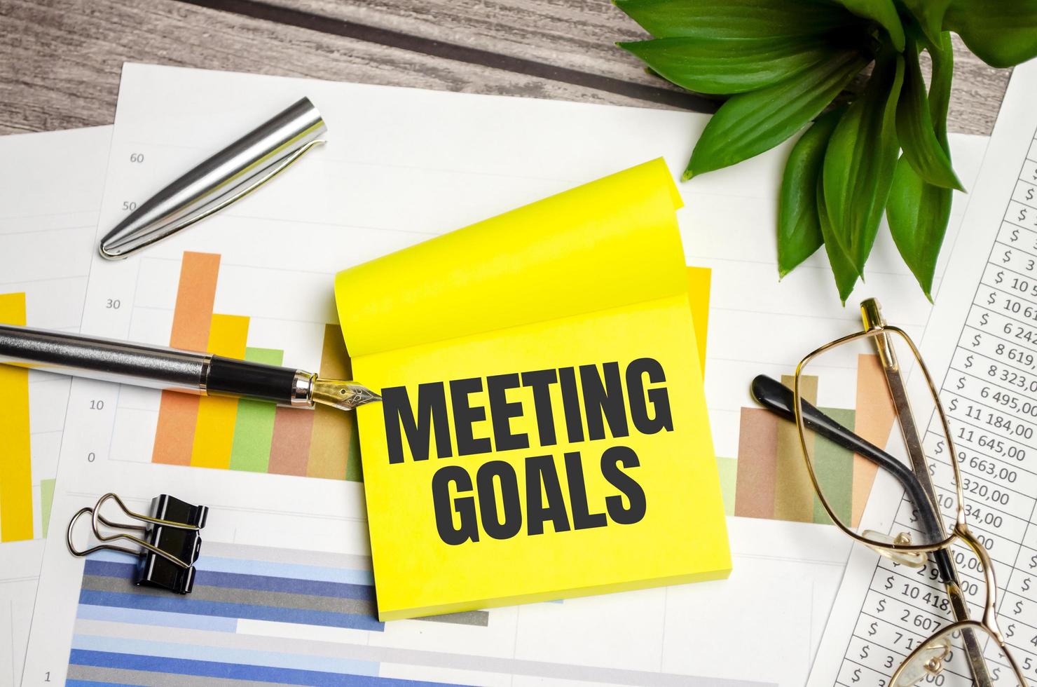 yellow sticker with the text MEETING GOALS and charts photo