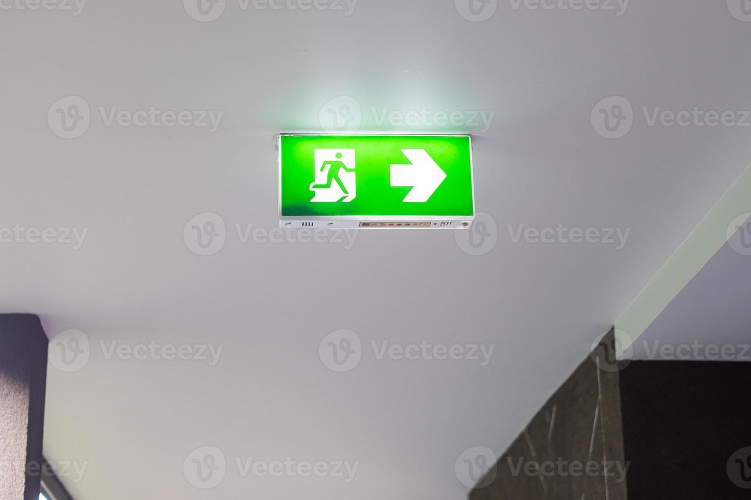 Fire Emergency exit sign on the wall background inside building. Safety concept photo