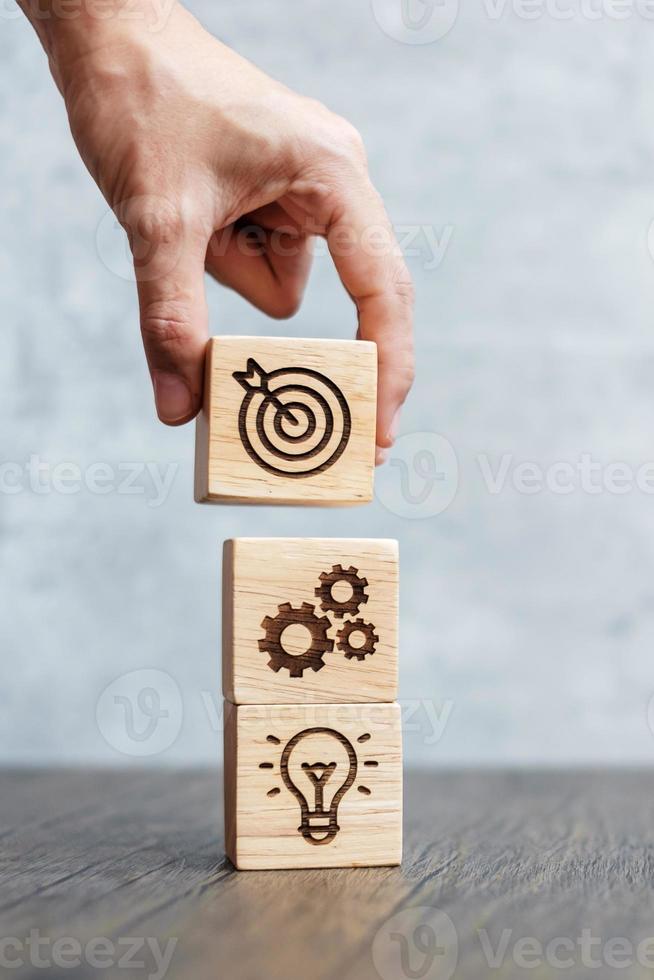 hand hold wood block with business goal, strategy, target, mission, action, objective, teamwork and idea concept photo