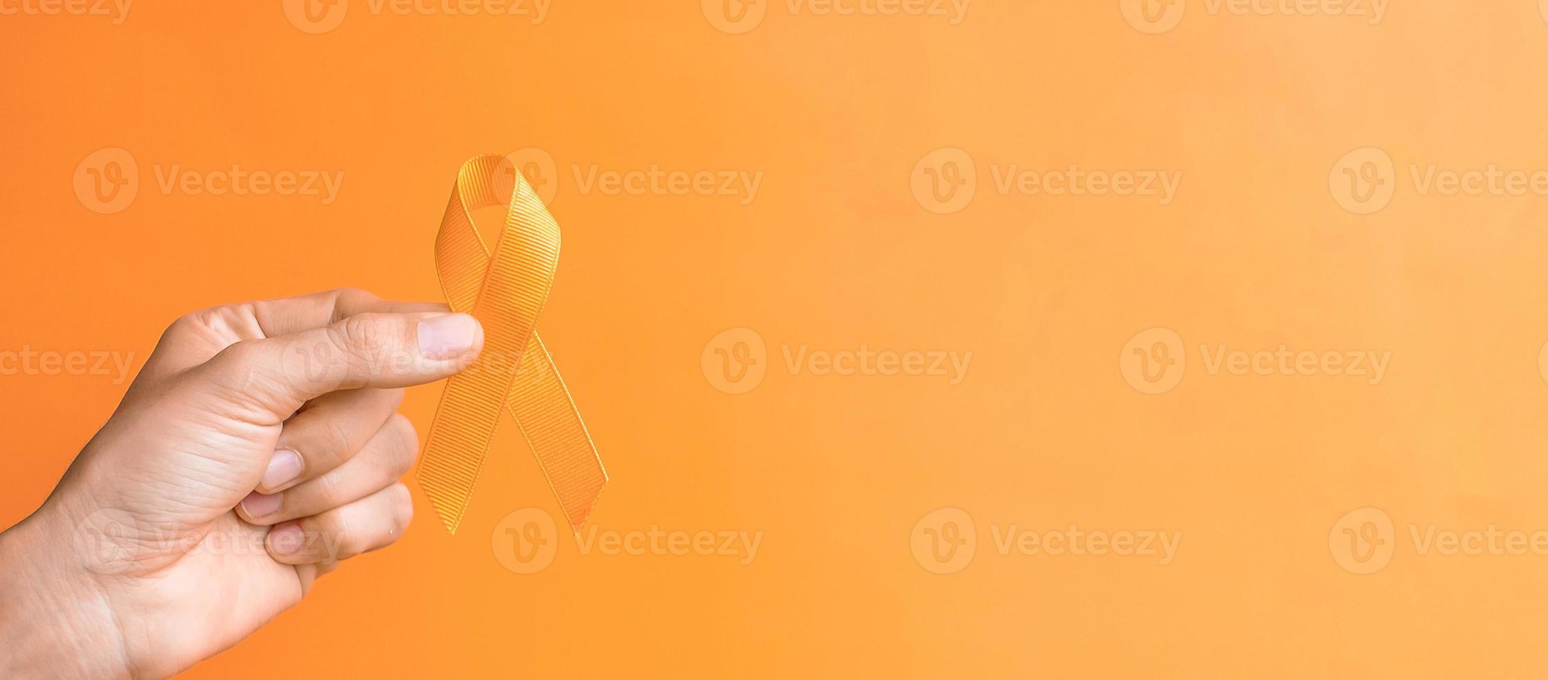 Leukemia, Kidney cancer day, world Multiple Sclerosis, CRPS, Self Injury Awareness month, hand holding Orange Ribbon for supporting people living and illness. Healthcare and World cancer day concept photo