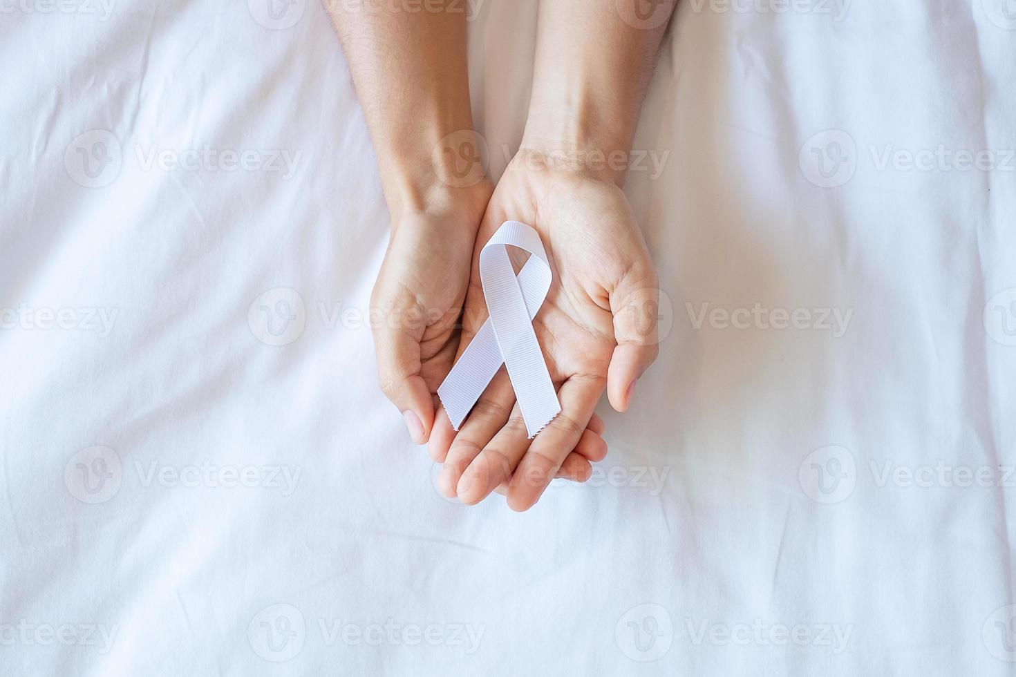 November Lung Cancer Awareness month, democracy and international peace day. Man holding white Ribbon on white background photo