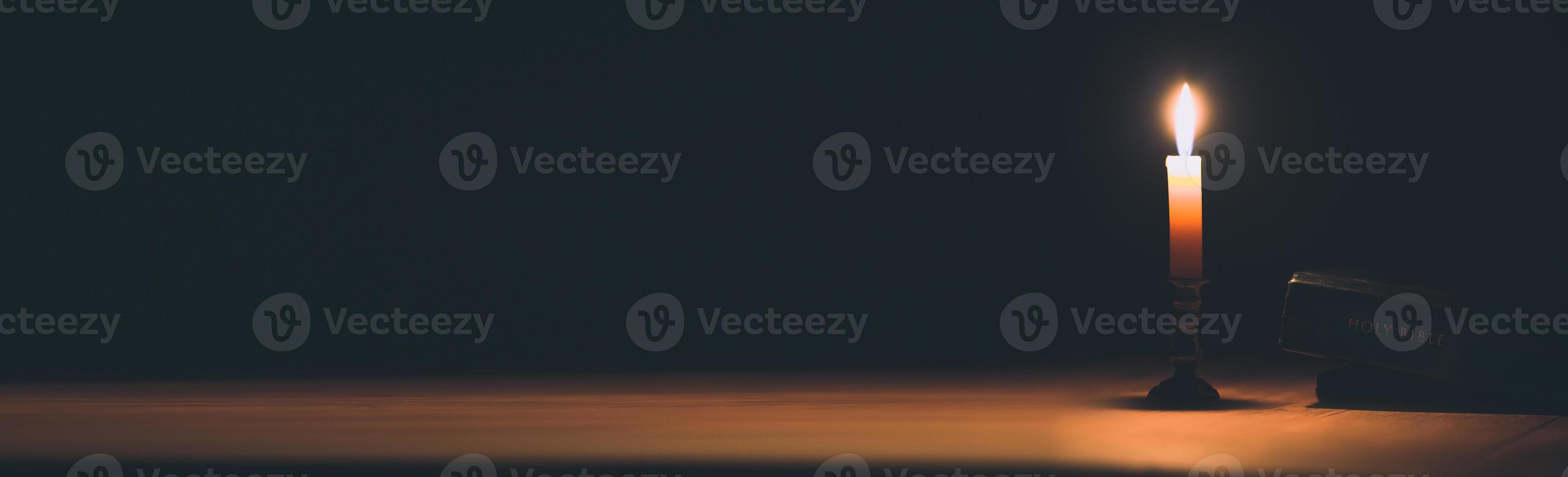 Banner image of Candle with bible on a old oak photo